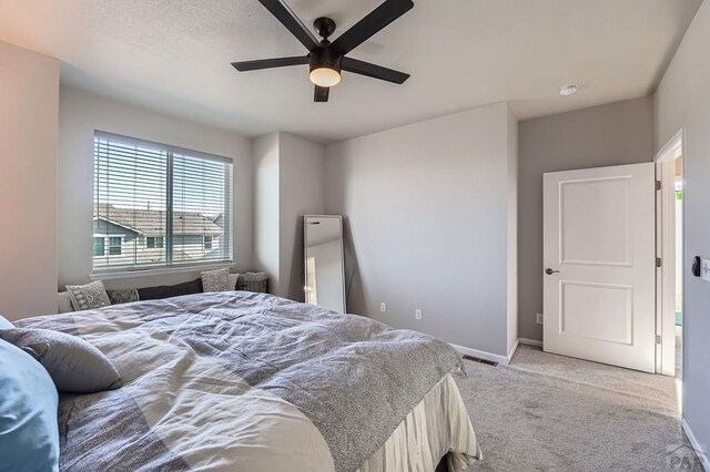 bedroom with light carpet, ceiling fan, and baseboards