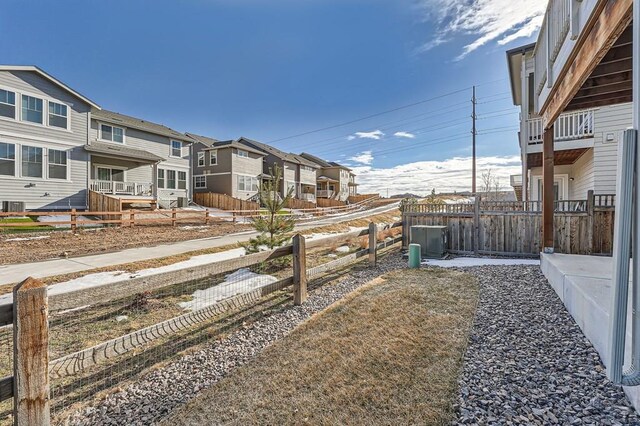 view of yard featuring central AC, fence private yard, and a residential view