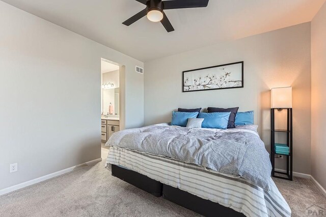 bedroom with visible vents, ensuite bathroom, light carpet, ceiling fan, and baseboards