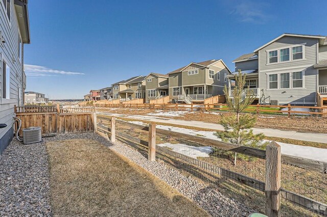 view of yard with cooling unit, a fenced backyard, and a residential view