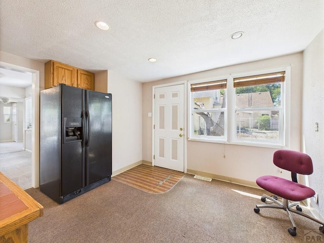 705 Euclid Ave, Pueblo, CO 81004 - kitchen with black refrigerator with ice dispenser, light carpet, a textured ceiling, recessed lighting, and brown cabinets
