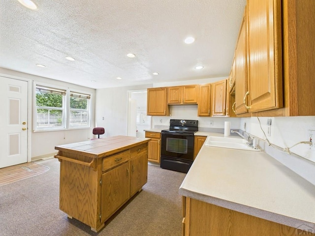 705 Euclid Ave, Pueblo, CO 81004 - kitchen featuring black / electric stove, a kitchen island, dark colored carpet, recessed lighting, and a textured ceiling
