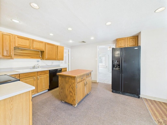 705 Euclid Ave, Pueblo, CO 81004 - kitchen with black appliances, a center island, recessed lighting, light countertops, and light carpet