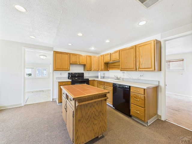 705 Euclid Ave, Pueblo, CO 81004 - kitchen with black appliances, a center island, light colored carpet, a textured ceiling, and tile countertops