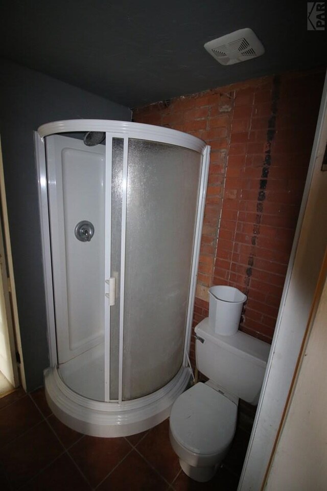 bathroom featuring toilet, a shower stall, visible vents, and tile patterned floors