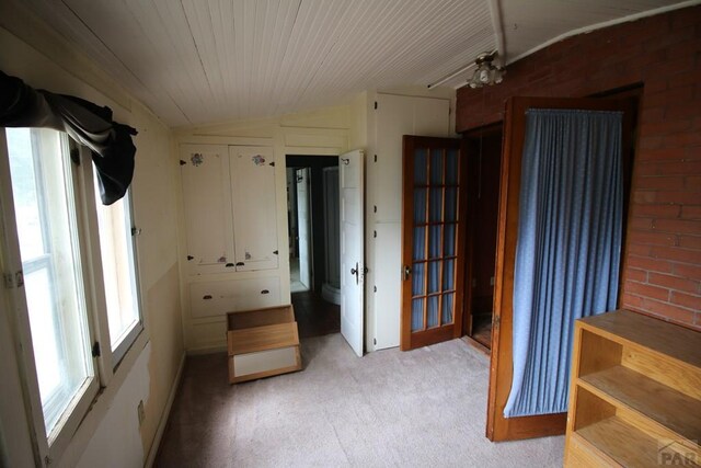 interior space with wooden ceiling, light carpet, and vaulted ceiling