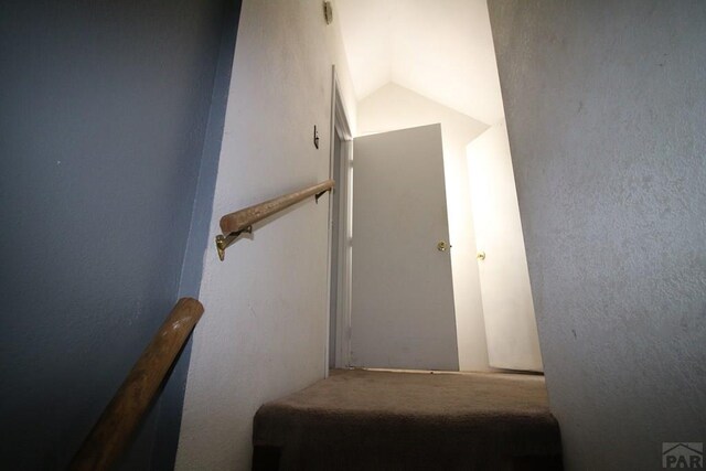 stairway featuring lofted ceiling