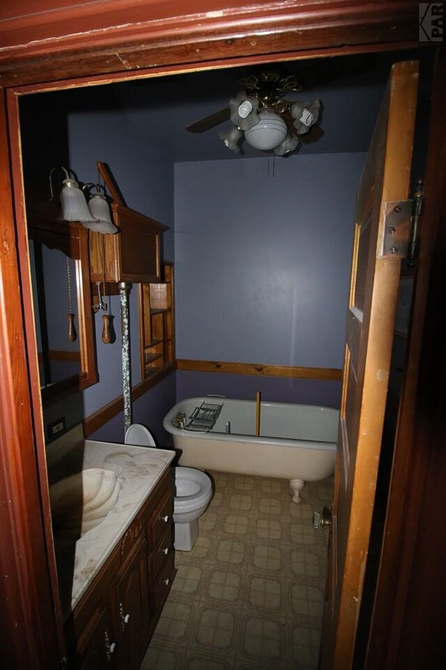 full bath with ceiling fan, toilet, vanity, a soaking tub, and tile patterned floors