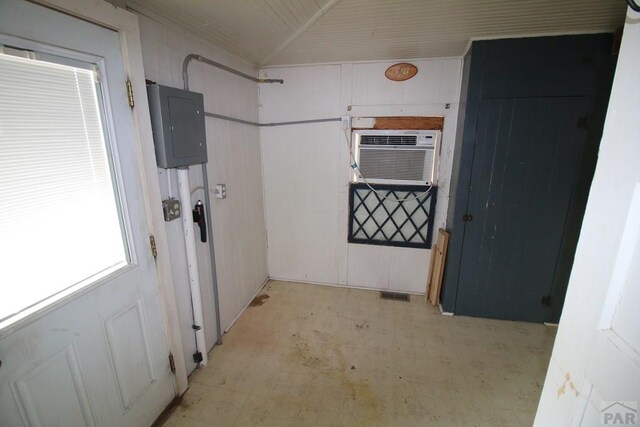 kitchen with light floors, electric panel, visible vents, and vaulted ceiling