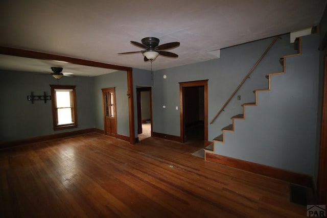 unfurnished living room with a ceiling fan, baseboards, stairway, and dark wood-style flooring