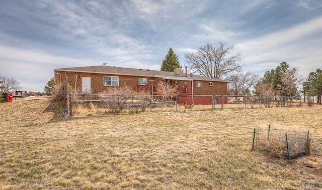11210 Eggar Dr, Peyton, CO 80831 - rear view of house with a lawn, brick siding, and fence