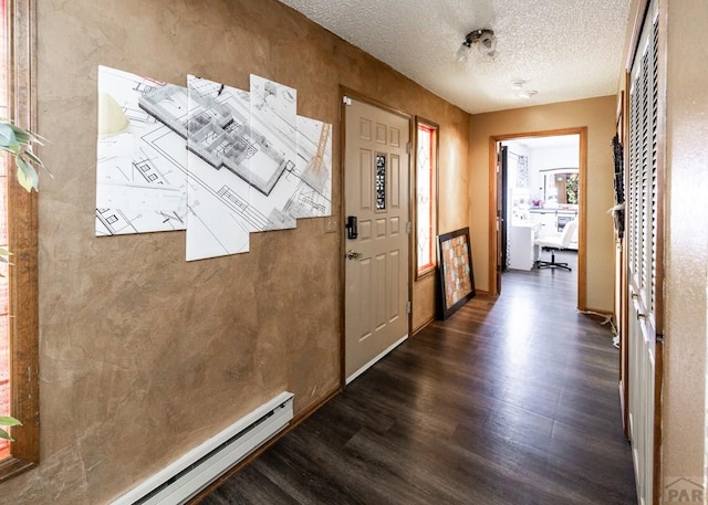 11210 Eggar Dr, Peyton, CO 80831 - entrance foyer with dark wood-type flooring, a textured ceiling, baseboards, and baseboard heating