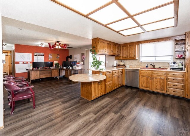 11210 Eggar Dr, Peyton, CO 80831 - kitchen with light countertops, a sink, dishwasher, a peninsula, and brown cabinets