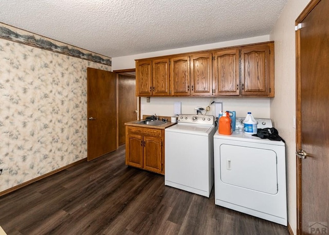 11210 Eggar Dr, Peyton, CO 80831 - laundry area with a sink, washing machine and clothes dryer, dark wood-style floors, wallpapered walls, and cabinet space