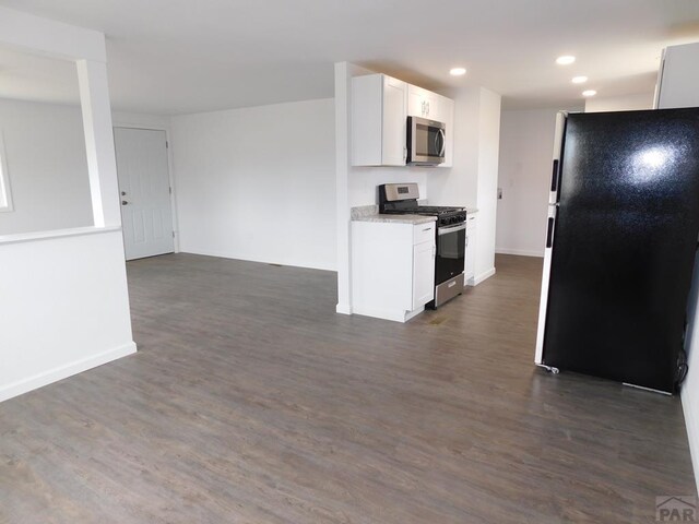 kitchen with appliances with stainless steel finishes, dark wood-type flooring, recessed lighting, and white cabinets