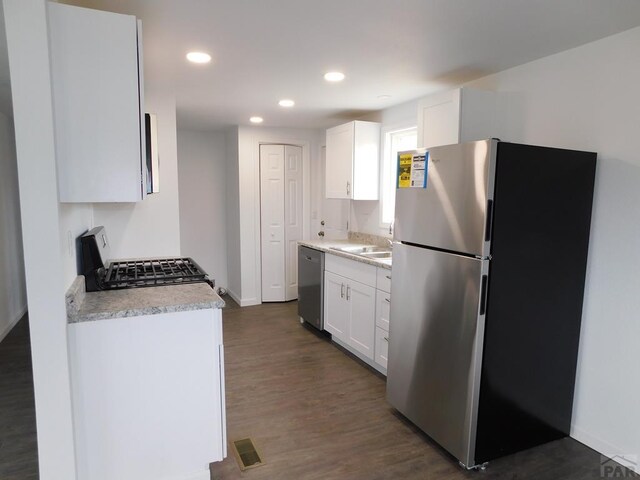 kitchen with visible vents, dark wood-style floors, appliances with stainless steel finishes, white cabinetry, and recessed lighting