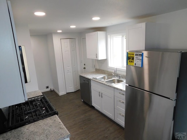 kitchen featuring dark wood-style flooring, stainless steel appliances, recessed lighting, white cabinets, and a sink