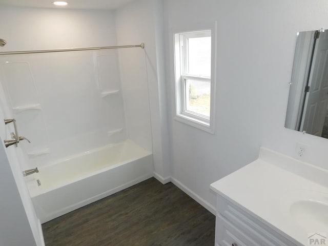 full bathroom featuring wood finished floors, shower / tub combination, vanity, and baseboards