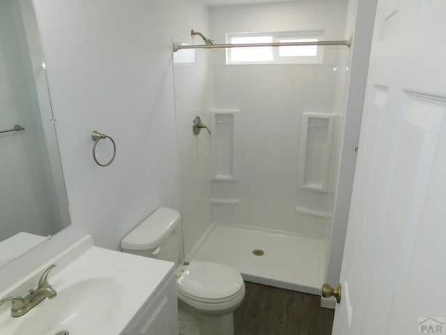 bathroom with toilet, a shower, and vanity