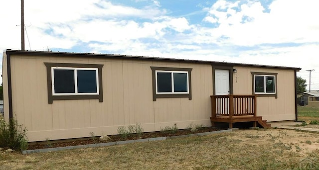 rear view of house with metal roof and a lawn