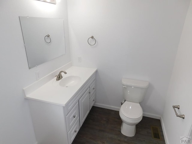 bathroom featuring toilet, wood finished floors, visible vents, vanity, and baseboards