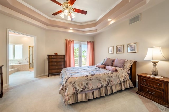 bedroom with visible vents, connected bathroom, light colored carpet, a tray ceiling, and crown molding