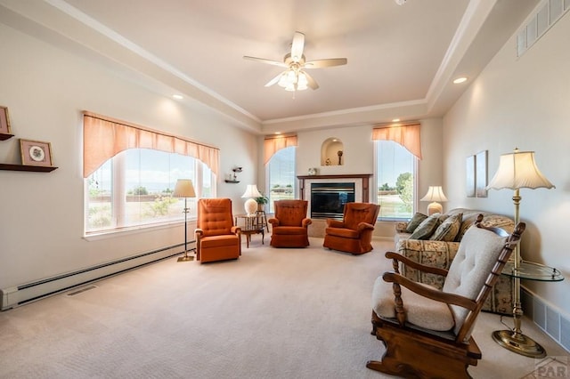 living area featuring visible vents, a glass covered fireplace, carpet floors, a baseboard heating unit, and a wealth of natural light