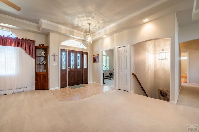 entrance foyer with a healthy amount of sunlight, a notable chandelier, and carpet flooring