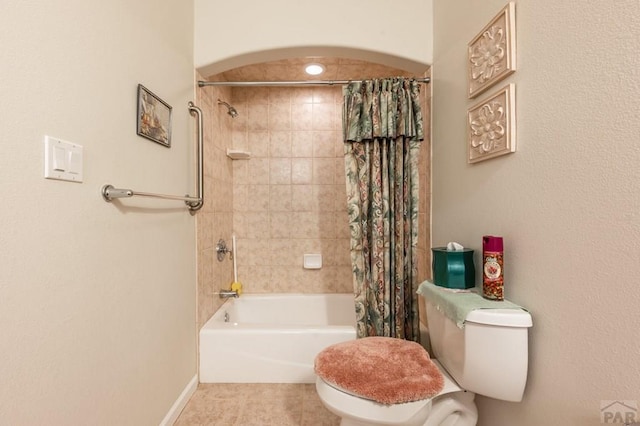 bathroom featuring toilet, baseboards, shower / bath combination with curtain, and tile patterned floors