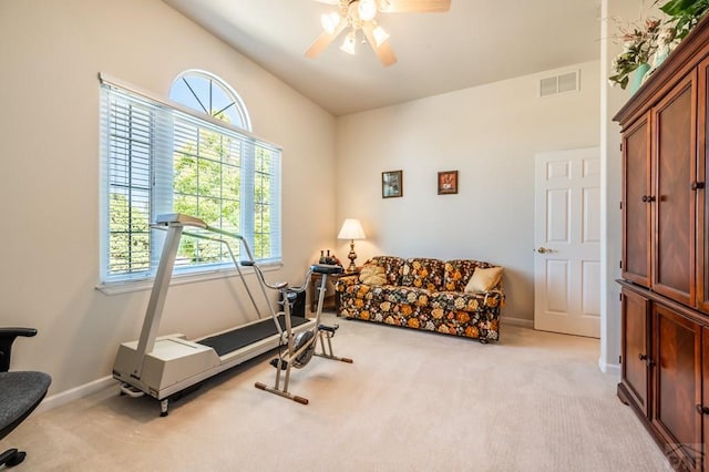 workout room featuring light colored carpet, ceiling fan, visible vents, and baseboards