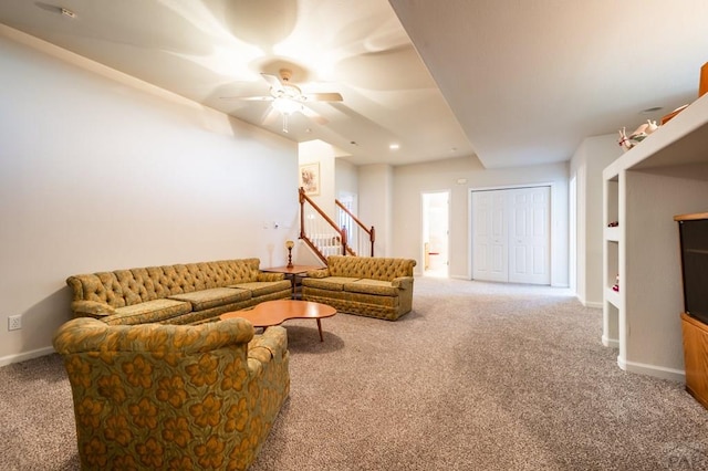 living room featuring carpet floors, baseboards, and a ceiling fan