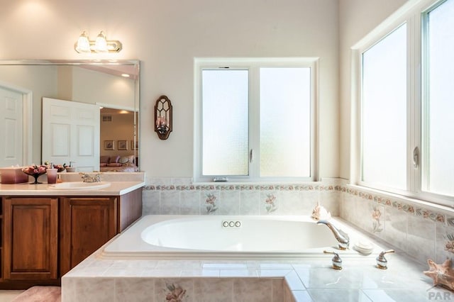 ensuite bathroom featuring ensuite bathroom, vanity, and a bath