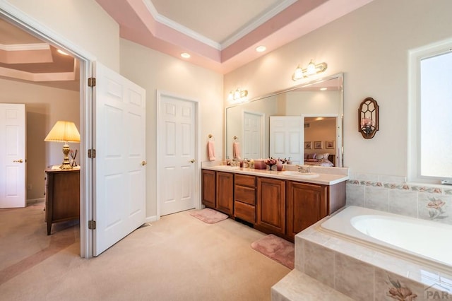 full bath with a sink, ornamental molding, a bath, double vanity, and a raised ceiling