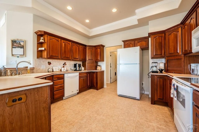 kitchen with white appliances, a sink, light countertops, decorative backsplash, and a tray ceiling