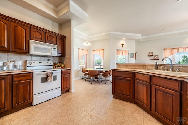 kitchen with white appliances, light tile patterned floors, decorative backsplash, crown molding, and a sink