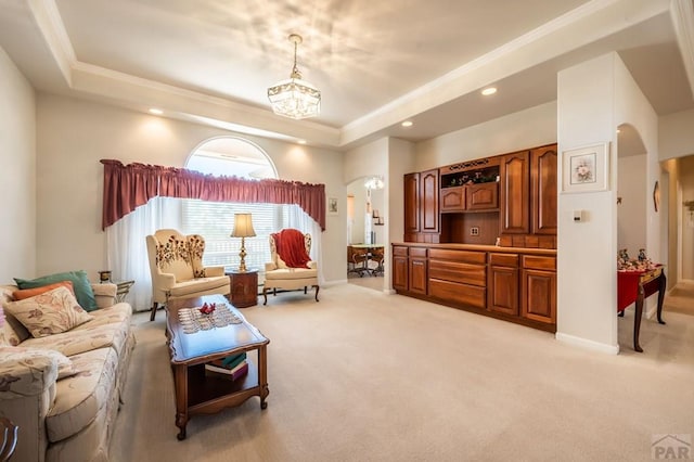 living area with arched walkways, light carpet, a raised ceiling, and baseboards