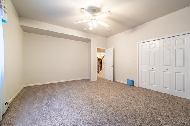 unfurnished bedroom with carpet floors, ceiling fan, baseboards, and a closet