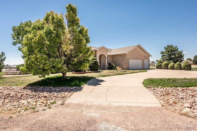 view of front of home featuring driveway, a garage, and stucco siding