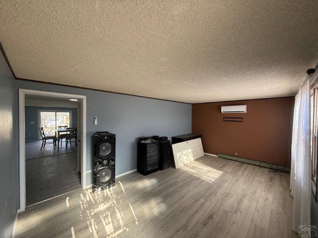 bar with baseboards, a wall unit AC, wood finished floors, baseboard heating, and a textured ceiling