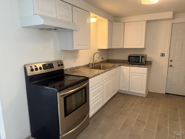 kitchen featuring stainless steel appliances, dark countertops, white cabinets, a sink, and under cabinet range hood