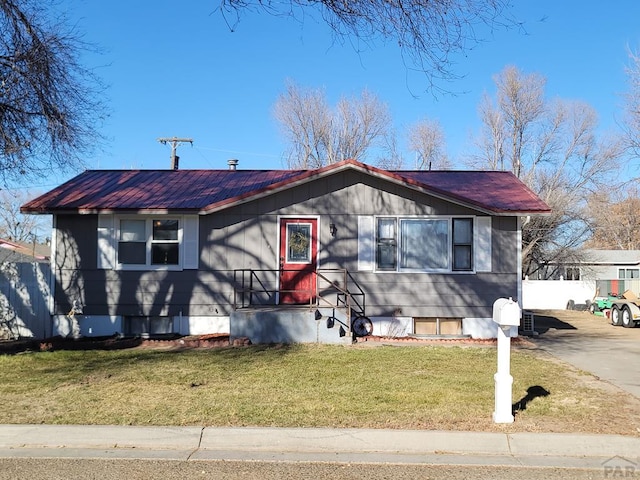 view of front of house with metal roof and a front yard