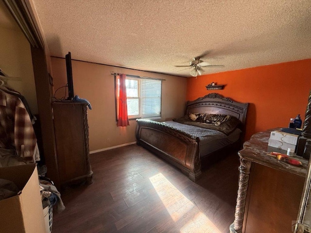 bedroom featuring dark wood-style floors, a textured ceiling, baseboards, and a ceiling fan