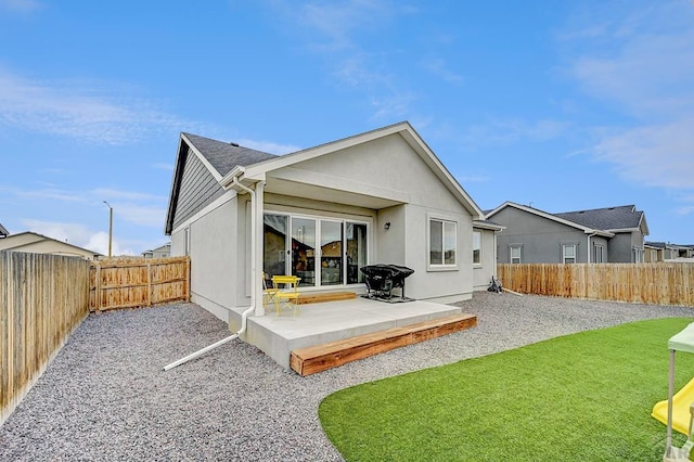 back of house featuring a yard, a fenced backyard, and a patio