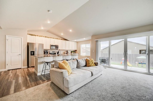 living room with vaulted ceiling, recessed lighting, wood finished floors, and baseboards