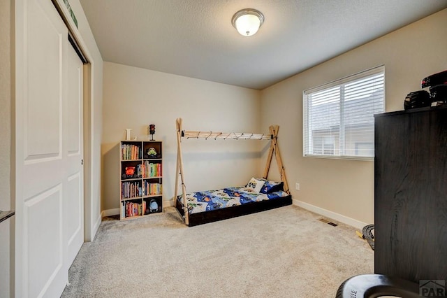 carpeted bedroom featuring visible vents and baseboards