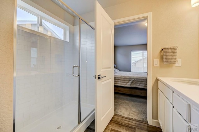 full bathroom with ensuite bathroom, a stall shower, and a healthy amount of sunlight