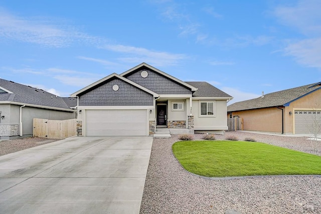 view of front facade with driveway, stone siding, an attached garage, and fence