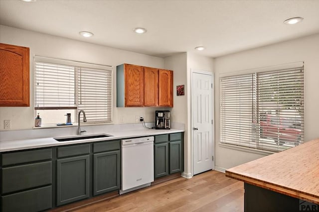 4315 Outlook Blvd Unit L, Pueblo, CO 81008 - kitchen with white dishwasher, a sink, light wood finished floors, light countertops, and recessed lighting