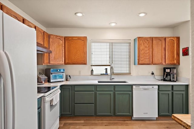 4315 Outlook Blvd Unit L, Pueblo, CO 81008 - kitchen featuring white appliances, green cabinets, under cabinet range hood, a sink, and light countertops