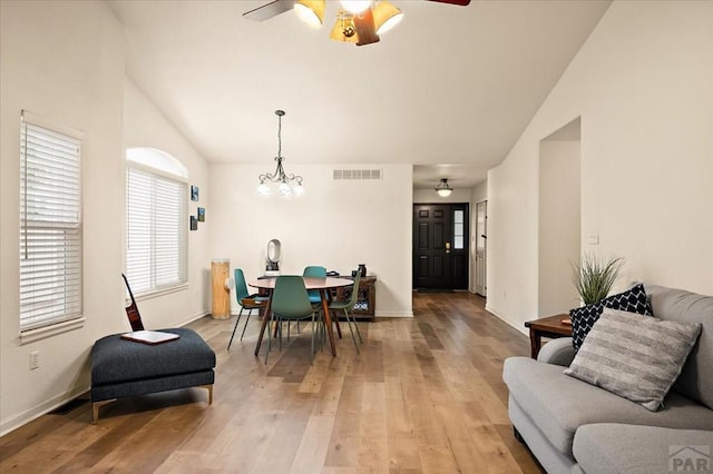 4315 Outlook Blvd Unit L, Pueblo, CO 81008 - dining room with lofted ceiling, a ceiling fan, light wood-style flooring, a chandelier, and baseboards